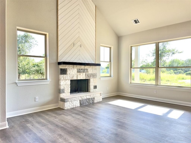 142 E Pauwela Ln, Bastrop, TX 78602 - unfurnished living room featuring wood finished floors, a stone fireplace, and high vaulted ceiling