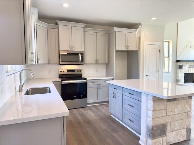 142 E Pauwela Ln, Bastrop, TX 78602 - kitchen featuring appliances with stainless steel finishes, gray cabinetry, decorative backsplash, dark wood finished floors, and recessed lighting