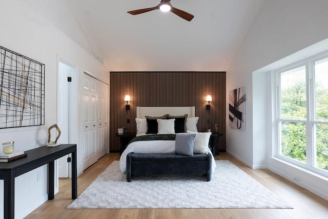 1402 Monica St, Austin, TX 78758 - bedroom featuring light wood finished floors, high vaulted ceiling, a ceiling fan, and an accent wall