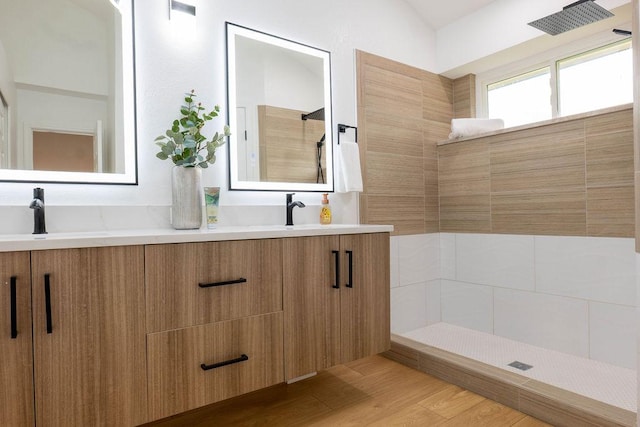1402 Monica St, Austin, TX 78758 - bathroom featuring double vanity, walk in shower, and wood finished floors