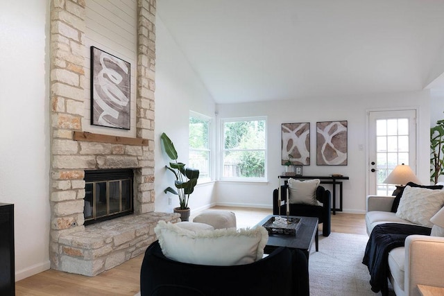 1402 Monica St, Austin, TX 78758 - living area with a stone fireplace, lofted ceiling, healthy amount of natural light, and light wood-style flooring