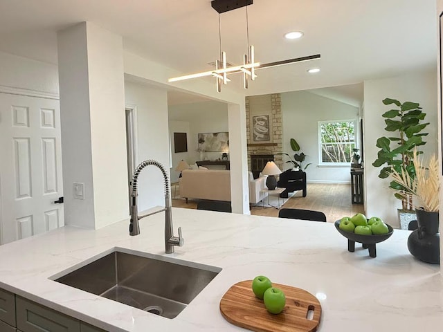 1402 Monica St, Austin, TX 78758 - kitchen featuring light stone countertops, pendant lighting, wood finished floors, open floor plan, and recessed lighting