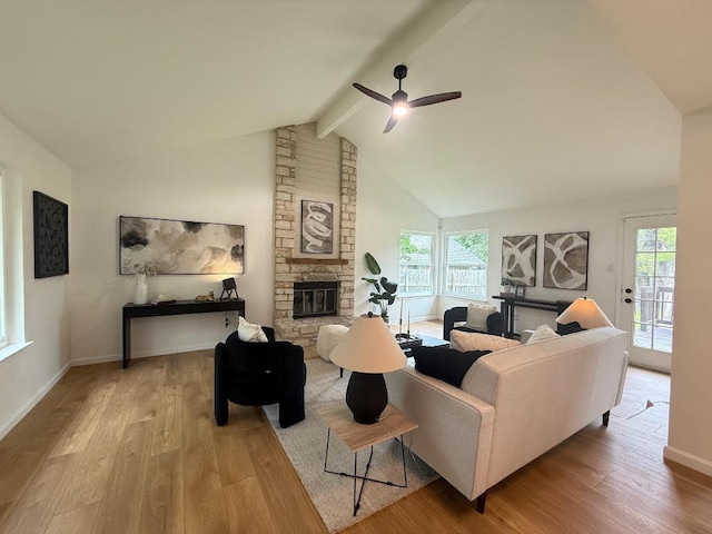 1402 Monica St, Austin, TX 78758 - living room with a stone fireplace, wood finished floors, and healthy amount of natural light