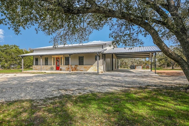 542 Stars And Stripes, Fischer, TX 78623 - view of front facade featuring an attached carport, dirt driveway, stone siding, a metal roof, and covered porch