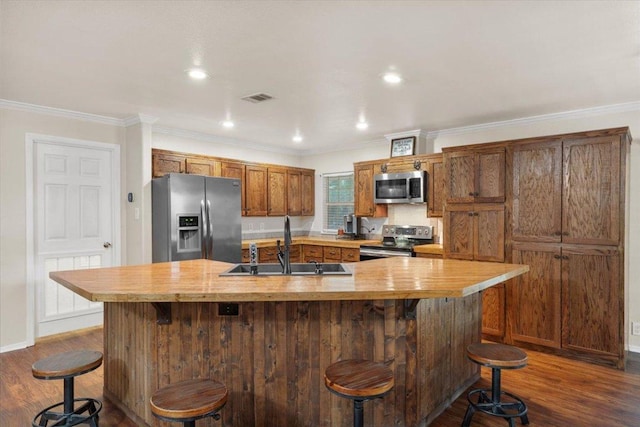 111 Lazy Trail Ct, Liberty Hill, TX 78642 - kitchen featuring appliances with stainless steel finishes, brown cabinets, dark wood-type flooring, light countertops, and crown molding