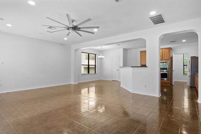 605 Whistlers Walk Trl, Cedar Park, TX 78613 - unfurnished living room featuring a ceiling fan, recessed lighting, dark tile patterned floors, arched walkways, and a chandelier