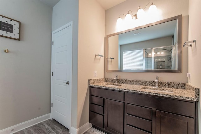 9213 Margaret Jewel Ln, Austin, TX 78748 - bathroom with double vanity, a shower stall, and wood finished floors