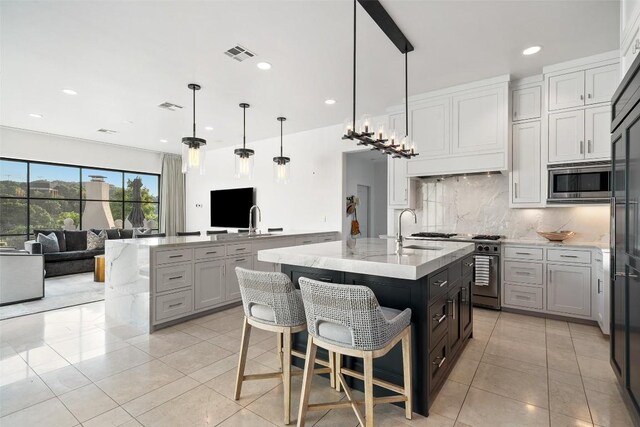 1508 Mesa Ridge Ln, Austin, TX 78735 - kitchen featuring stainless steel appliances, a kitchen island with sink, open floor plan, decorative backsplash, and light stone countertops