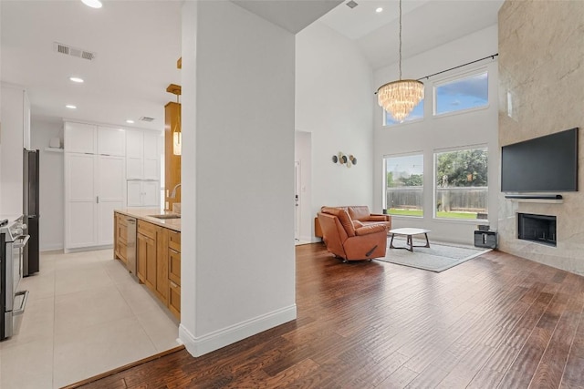 2817 Barefoot Ln, Round Rock, TX 78665 - living area featuring a fireplace, a chandelier, light wood-type flooring, high vaulted ceiling, and recessed lighting