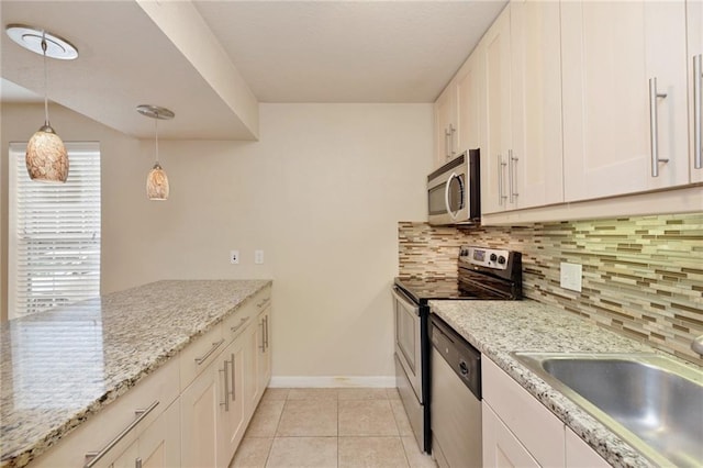 7685 Northcross Dr Unit 605, Austin, TX 78757 - kitchen featuring stainless steel appliances, tasteful backsplash, white cabinets, and hanging light fixtures