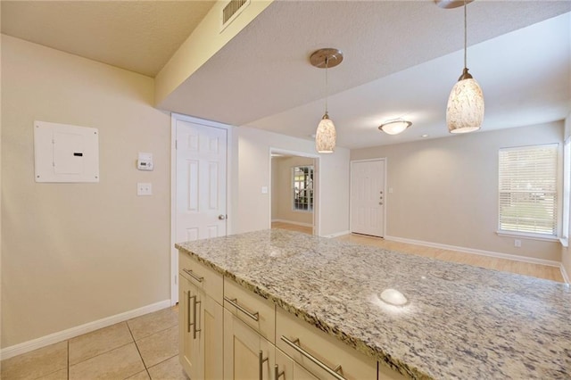 7685 Northcross Dr Unit 605, Austin, TX 78757 - kitchen with electric panel, decorative light fixtures, light stone countertops, and light tile patterned floors