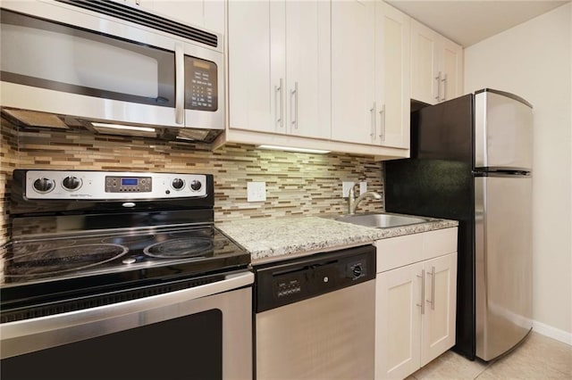 7685 Northcross Dr Unit 605, Austin, TX 78757 - kitchen featuring stainless steel appliances, white cabinetry, tasteful backsplash, and light tile patterned flooring