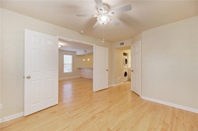 7685 Northcross Dr Unit 605, Austin, TX 78757 - empty room with stacked washing machine and dryer, light wood-style flooring, ceiling fan, and a smoke detector