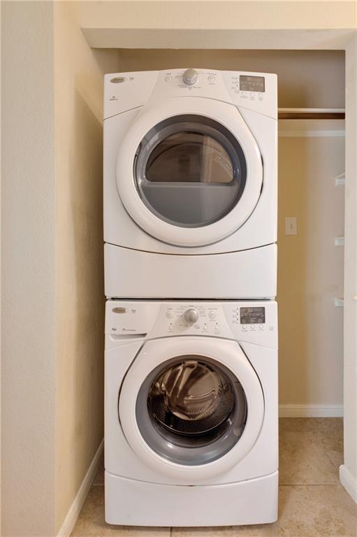 7685 Northcross Dr Unit 605, Austin, TX 78757 - laundry area featuring stacked washing machine and dryer and baseboards