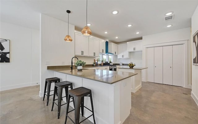 7306 Carver Ave Unit 1, Austin, TX 78752 - kitchen featuring wall chimney range hood, concrete flooring, a peninsula, stainless steel range oven, and recessed lighting