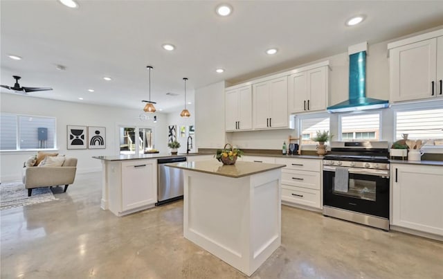 7306 Carver Ave Unit 1, Austin, TX 78752 - kitchen with appliances with stainless steel finishes, wall chimney range hood, finished concrete flooring, a peninsula, and recessed lighting