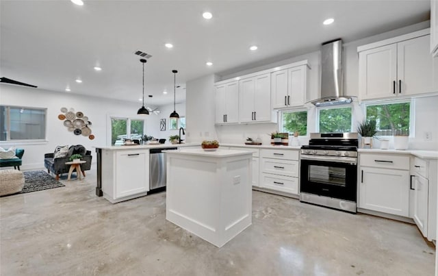 7613 Providence Ave Unit 1, Austin, TX 78752 - kitchen with stainless steel appliances, wall chimney range hood, finished concrete flooring, a peninsula, and recessed lighting