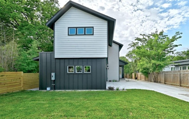 7613 Providence Ave Unit 1, Austin, TX 78752 - rear view of house with board and batten siding, a patio, and driveway