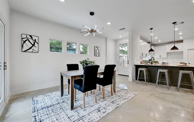7613 Providence Ave Unit 1, Austin, TX 78752 - dining room with finished concrete flooring, healthy amount of natural light, recessed lighting, and a chandelier