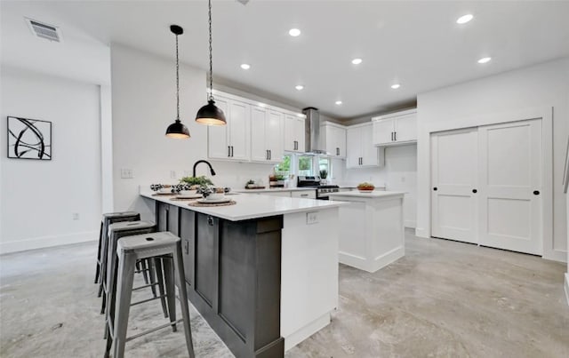 7613 Providence Ave Unit 1, Austin, TX 78752 - kitchen with finished concrete flooring, stainless steel range oven, wall chimney exhaust hood, a peninsula, and light countertops