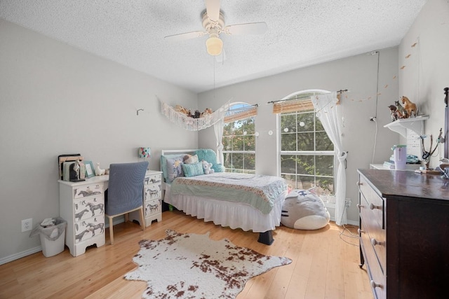 1306 River Oak Dr, Leander, TX 78641 - bedroom featuring a textured ceiling, light wood-style floors, and ceiling fan