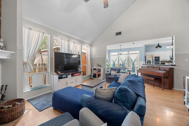 1306 River Oak Dr, Leander, TX 78641 - living room with plenty of natural light, light wood-type flooring, a ceiling fan, and high vaulted ceiling