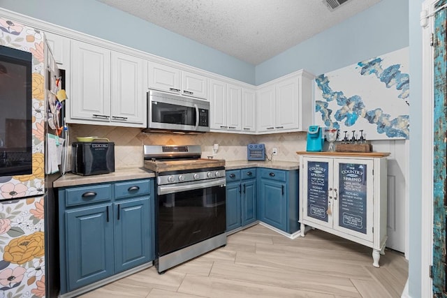 1306 River Oak Dr, Leander, TX 78641 - kitchen featuring appliances with stainless steel finishes, blue cabinetry, light countertops, tasteful backsplash, and a textured ceiling