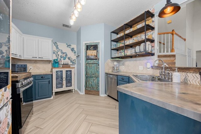 1306 River Oak Dr, Leander, TX 78641 - kitchen with stainless steel appliances, blue cabinetry, white cabinetry, decorative backsplash, and light countertops