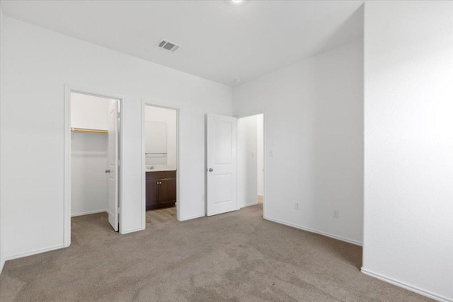 14320 Tordillo Dr, Elgin, TX 78621 - unfurnished bedroom with light colored carpet, a spacious closet, ensuite bath, and a closet