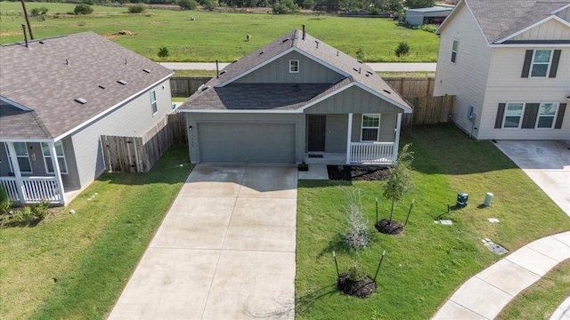 14320 Tordillo Dr, Elgin, TX 78621 - view of front of property featuring driveway, an attached garage, a shingled roof, and covered porch