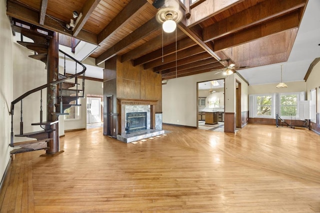 1001 S Gabriel Dr, Leander, TX 78641 - unfurnished living room with a ceiling fan, a wooden ceiling with exposed beams, light wood-style flooring, stairway, and a tiled fireplace