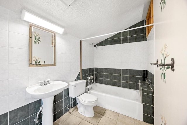 1001 S Gabriel Dr, Leander, TX 78641 - bathroom with tile walls, tile patterned floors, a textured ceiling, and washtub / shower combination