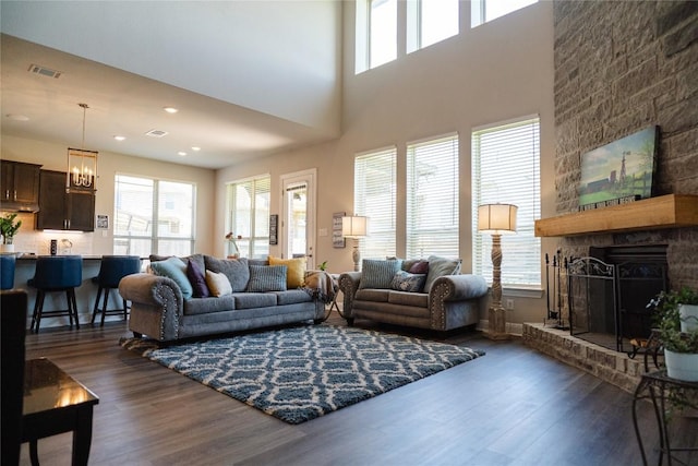 2616 Pine Branch Rd, Leander, TX 78641 - living area featuring dark wood-style flooring, a chandelier, a large fireplace, recessed lighting, and a towering ceiling