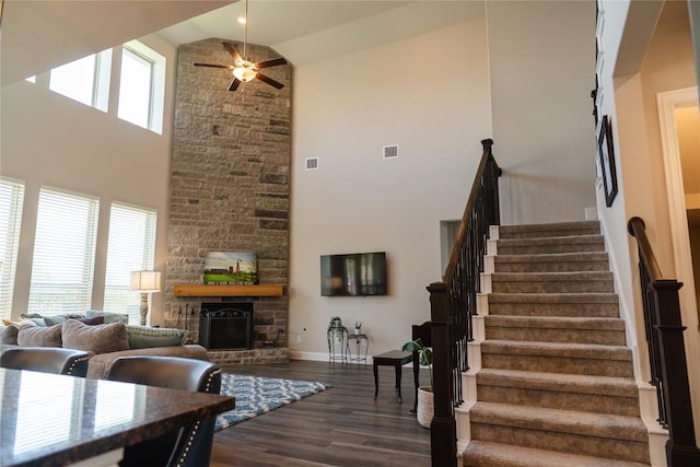 2616 Pine Branch Rd, Leander, TX 78641 - living area with high vaulted ceiling, dark wood finished floors, a ceiling fan, a stone fireplace, and stairs