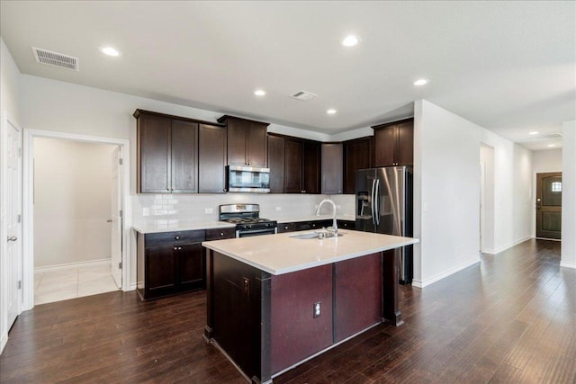 1629 W Broade St, Leander, TX 78641 - kitchen with stainless steel appliances, tasteful backsplash, an island with sink, light countertops, and dark wood-type flooring
