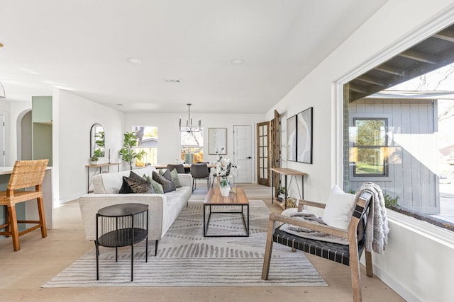 2105 Brunswick, Austin, TX 78723 - living room with a chandelier, arched walkways, and light wood-type flooring