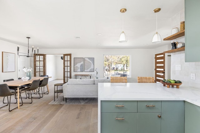 2105 Brunswick, Austin, TX 78723 - kitchen featuring green cabinets, a peninsula, light wood-type flooring, and a chandelier