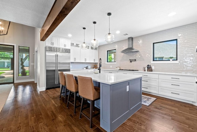 104 Hazeltine Dr, Georgetown, TX 78628 - kitchen featuring stainless steel built in refrigerator, wall chimney range hood, dark wood-type flooring, light countertops, and recessed lighting
