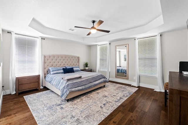 104 Hazeltine Dr, Georgetown, TX 78628 - bedroom with a raised ceiling, dark wood-style floors, and a ceiling fan