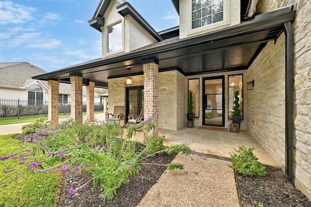 104 Hazeltine Dr, Georgetown, TX 78628 - doorway to property featuring stone siding and a porch