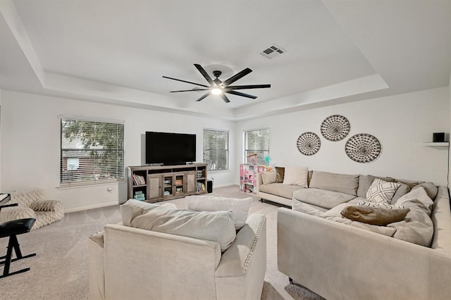 104 Hazeltine Dr, Georgetown, TX 78628 - living room featuring a tray ceiling, carpet floors, ceiling fan, and plenty of natural light