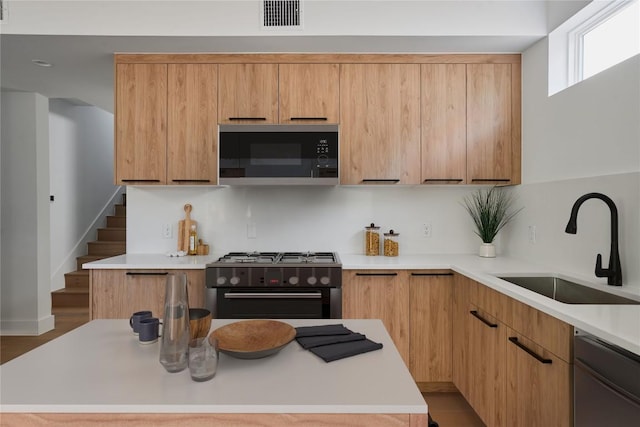 7516 Northcrest Blvd Unit 2, Austin, TX 78752 - kitchen featuring black microwave, range with gas stovetop, stainless steel dishwasher, light countertops, and modern cabinets