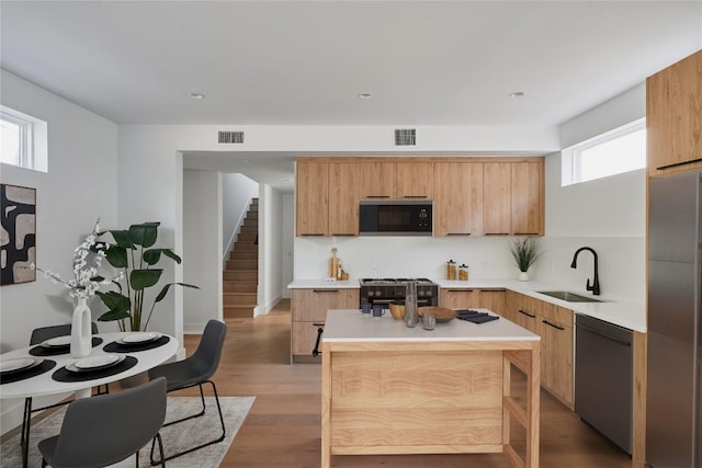 7516 Northcrest Blvd Unit 2, Austin, TX 78752 - kitchen with black appliances, plenty of natural light, light countertops, and light wood-style flooring