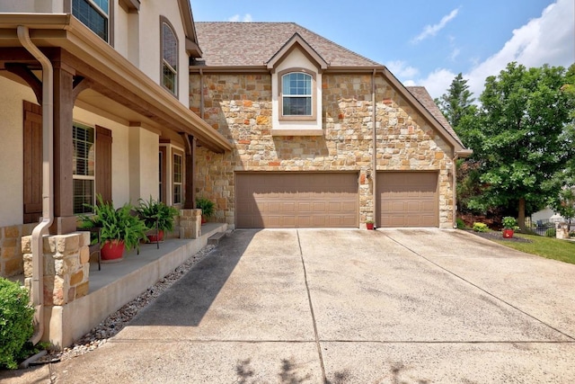 106 Tonkawa Trl W, Austin, TX 78738 - view of front of home with stone siding, concrete driveway, and a garage