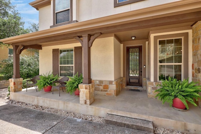 106 Tonkawa Trl W, Austin, TX 78738 - view of exterior entry with a porch, stucco siding, and stone siding