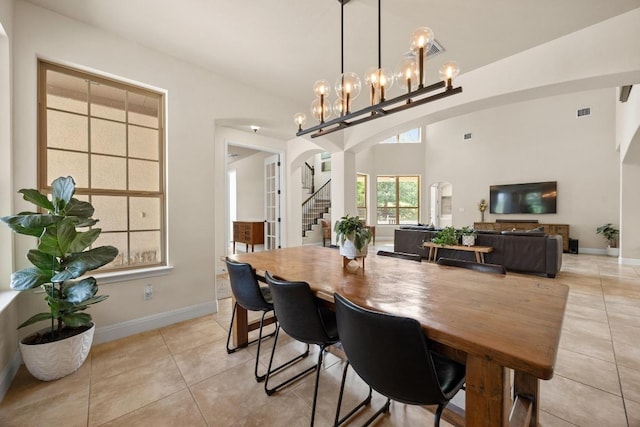 106 Tonkawa Trl W, Austin, TX 78738 - dining space featuring light tile patterned floors, stairs, arched walkways, and a chandelier