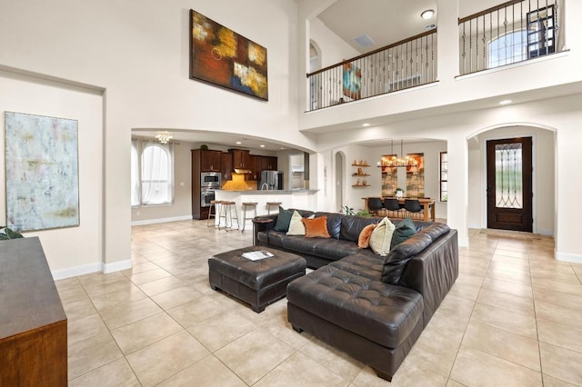 106 Tonkawa Trl W, Austin, TX 78738 - living area featuring light tile patterned floors, arched walkways, a towering ceiling, and a chandelier