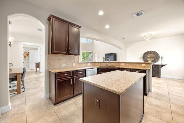106 Tonkawa Trl W, Austin, TX 78738 - kitchen with arched walkways, stainless steel dishwasher, tasteful backsplash, dark brown cabinets, and recessed lighting