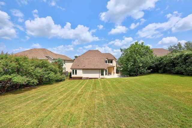 106 Tonkawa Trl W, Austin, TX 78738 - back of house featuring stucco siding, a lawn, and a patio area