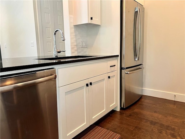 1126 Linden St Unit 2, Austin, TX 78702 - kitchen with stainless steel appliances, dark wood finished floors, white cabinetry, tasteful backsplash, and dark countertops